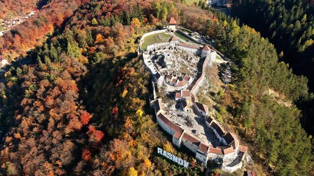 Aerial drone view of The Rasnov Fortress in Romania. Medieval fortress with Rasnov inscription on the top of the hill, tourists
