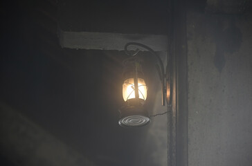 Vintage lantern with a light bulb inside hangs on the wall
