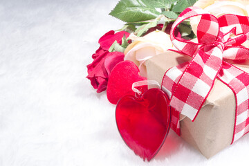 Valentine's Day holiday background. Craft paper gift box with ribbon, rose flowers and hearts decor, copy space