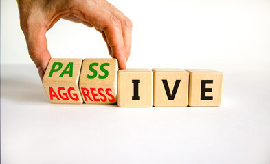 Passive or aggressive symbol. Businessman turns wooden cubes and changes the word passive to...