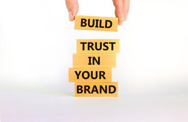 Success business process symbol. Wood blocks stacking as step stair on beautiful white background, copy space. Businessman hand. Words 'build trust in your brand'. Business and trust brand concept.