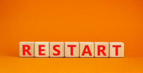 Restart and start symbol. The concept word Restart on wooden cubes. Beautiful orange table, orange...