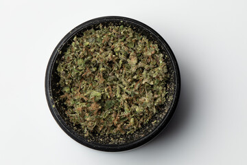 Grinder with Crushed buds of marijuana weed cannabis isolated, medical marijuana