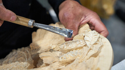 Artisan carver makes decorative panels.