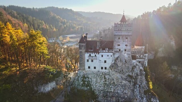 Aerial drone view of The Bran Castle in Romania. Medieval castle in Carpathians, yellowed trees, tourists