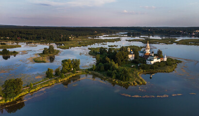 calm landscape with Orthodox monastery on an island in the middle of a peaceful lake, top view