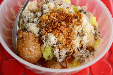 Xoi yen, vietnamese dish made from sticky rice cooked with turmeric and topped with fried garlic, onions, shredded chicken or pork and fried quail eggs