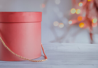 Pink gift box on a wooden table on a bokeh background