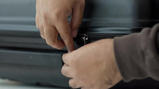 Close up male hand zipping and lock the luggage by input security codes. Man organizer luggage suitcase. 