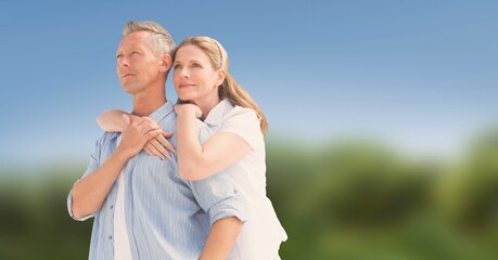 Composite image of caucasian senior couple hugging against blurred background