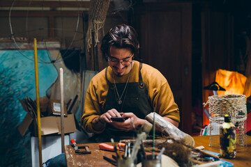 man using smartphone in his workshop