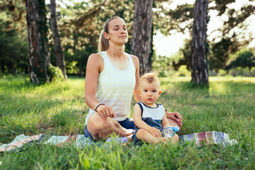 mother with her baby boy do exercises in public park