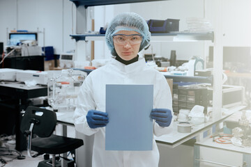 Portrait of young scientist or medic holding journal or notes in laboratory