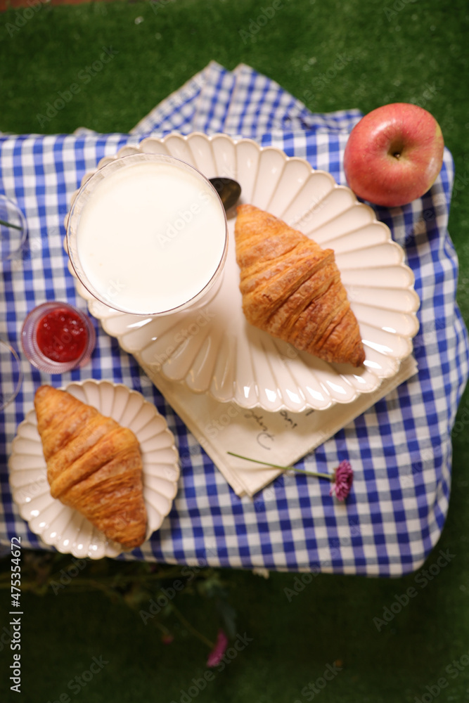 Sticker Top view of fresh croissants with a sweet dessert, jam and apple outdoors in the park