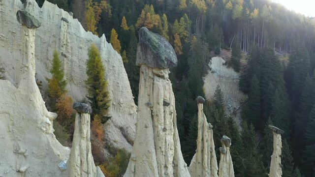 Aerial view on natural Earth Pyramids of Platten in autumn Dolomite Alps. Perca, Dolomites, Italy. UHD 4k drone video