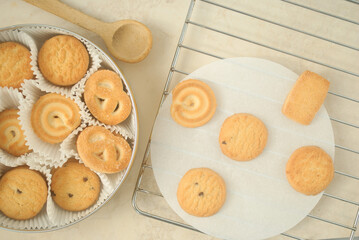 cookies on a kitchen top with a wooden spoon and a metalic grid 