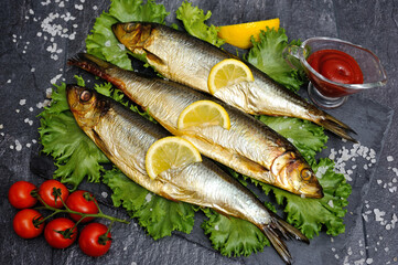 herring fish with vegetables on a black background top view, concept of fish market