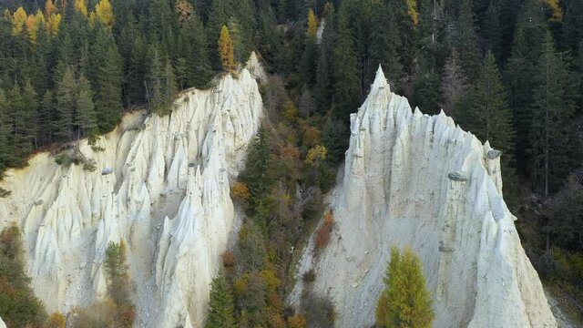 Aerial view on natural Earth Pyramids of Platten in autumn Dolomite Alps. Perca, Dolomites, Italy. UHD 4k drone video