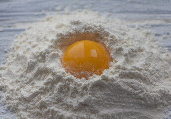 Egg on flour, top view, ingredients for baking