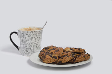 cup of coffee with milk and a white plate with cookies, isolated on white background