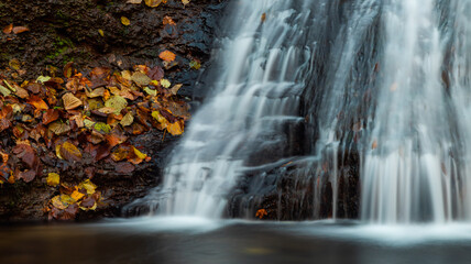 Fototapeta na wymiar Tranquil waterfall scenery in the middle of autumn forest