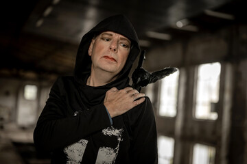 Mensch mit Raben auf der Schulter blickt einsam ins Leere