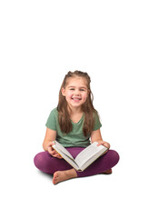 isolated girl sitting with a book on her lap, reading and smiling on a white background