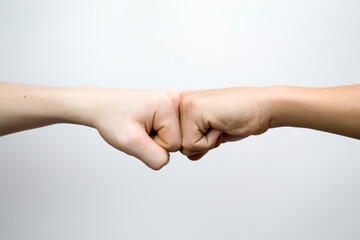 The blow of two fists on a white background, the meeting of friends, the olicitation of the conflict.