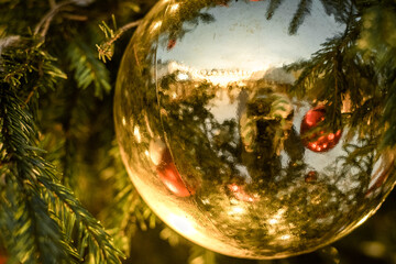 High Christmas tree adorned red and gold balls. New Year's decor on the tree