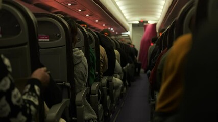 Low cost airplane interior with passengers on the seats at sunrise