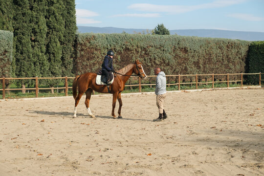 Young boy learning horse riding with teacher.