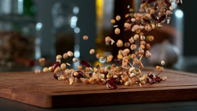 Camera Movement. Super Slow Motion Shot of Falling Legumes on Wooden Kitchen Board, Filmed on High Speed Cinematic Camera at 1000 fps.