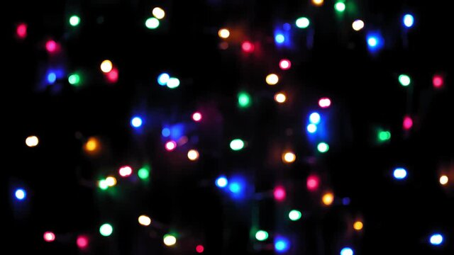 4k. Christmas mood, round defocused multicolored lights. Beautiful New Year screensaver. Merry christmas congratulation. Abstract background of glowing garlands at night. Christmas Garland