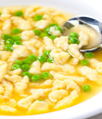chicken bouillon with homemade dumplings and green peas