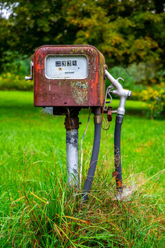 Vertical shot of a vintage rusty gas pamp in a park
