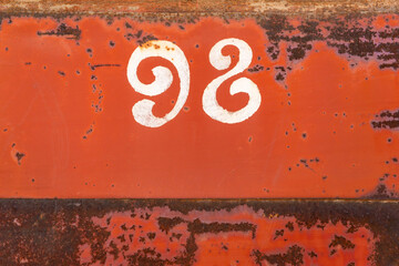 numbers ninety eight on a rusty iron door red door white numbers nine and eight