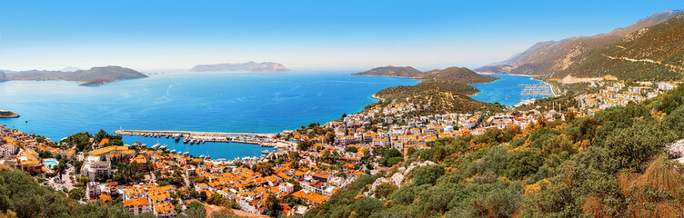 Fototapeta na wymiar Charming panoramic aerial view of seaside resort town of Kas in Turkey. Harbor with port and white houses with orange roofs waiting for tourists. Turkish riviera and vacation