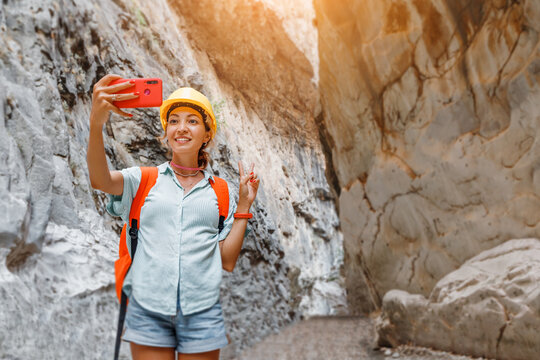 Happy woman taking selfie photo during active canyoning and hiking along the Saklikent Gorge in Turkey. New travel experience and outdoor recreation