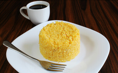 Couscous and coffee. Brazilian breakfast with corn couscous and coffee cup.