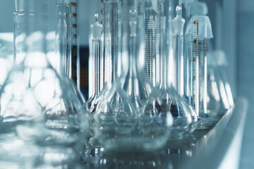 Laboratory flasks in a row on a shelf in the laboratory.