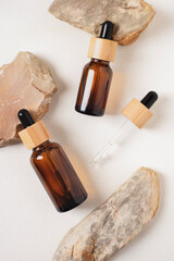 Amber glass dropper bottles with bamboo lid on stones. Skincare products, natural cosmetic. Beauty concept for face and body care.