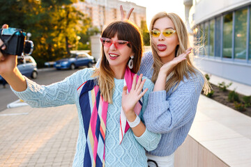 Outdoor sunny lifestyle portrait of happy exited couple of elegant girls