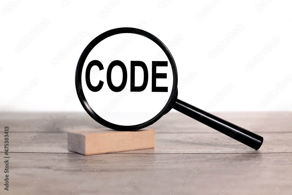 Poster code. text inside the magnifier. magnifying glass on a wooden table on a white background