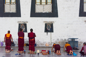 Monks prostrate themselves praying before Jokhang Temple, part of the 'Historic Ensemble of the...