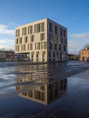 Rolgordijnen Mortsel town hall also called MASke . Modern building reflection in puddle and blue sky © Tom