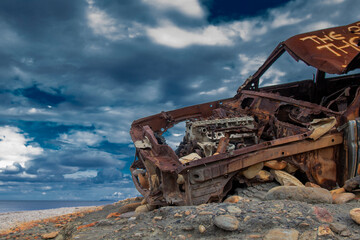 old rusty car on the beach of the north sea - obrazy, fototapety, plakaty