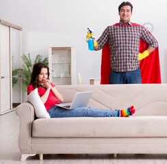 Obraz premium Superhero husband helping his wife at home