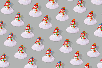 Creative winter pattern with snowman and snow on gray background
