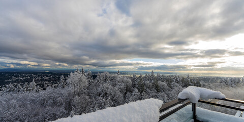 Snowed in on a Burnaby Mountain rooftop patio during winter  with extensive views over snow-capped...