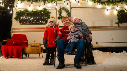 Fototapeta na wymiar Caucasian man and three sons celebrate Christmas in a mobile home.